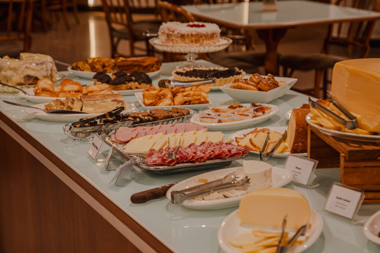 Mesa de frios com queijos, presunto e salame fatiados